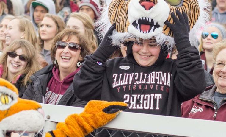 Kelsey Peavler smiles as Clawz the mascot greets her at the 2017 同学会 Football Game